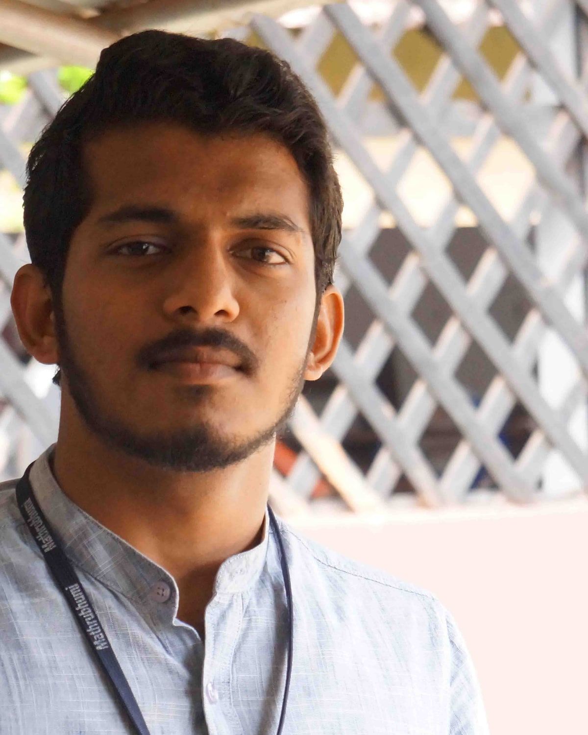 Portrait of Thajudeen Aboobaker from his Fab Academy 2019 page, outdoors in front of a lattice wall.